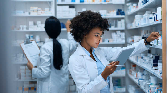 Female Pharmacist Checking Inventory on Tablet
