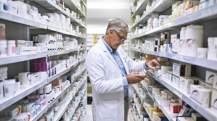 Older Male Pharmacist Stocking Shelves